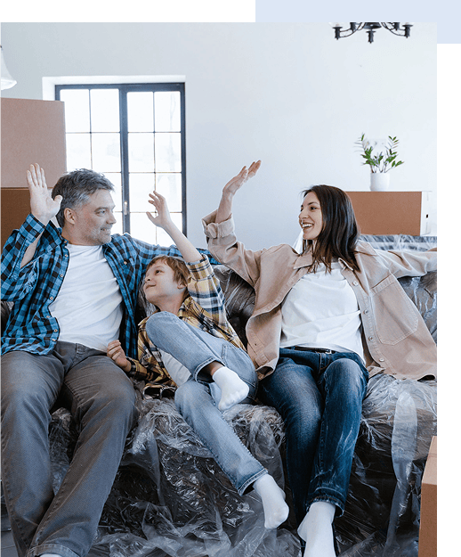 Eine glückliche, junge Familie mit Kind auf einem Sofa in ihrer neuen Wohnung, die sie mit Grünewald immobilien gefunden haben (Wohnung kaufen, Haus kaufen)